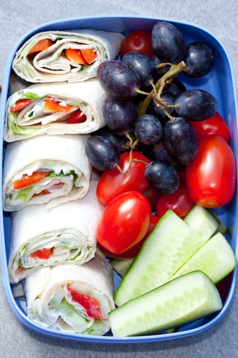 Lunchbox mit Tortilla Wrap Röllchen, Gurkensticks, Snacktomaten und Weintrauben